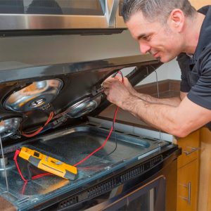 Jusproa Technician with multimetre conducting stove repair